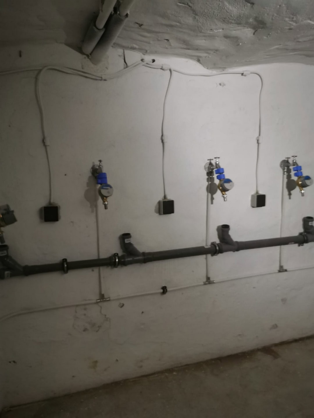 Rohrleitungsinstallation im Keller, Wasserrohre und Wasserzähler, hygienische Sanitärtechnik, DEM GROUP professioneller Heizungs- und Sanitärservice, effiziente Wasserverteilung, Sanitärinstallationen in Deutschland.