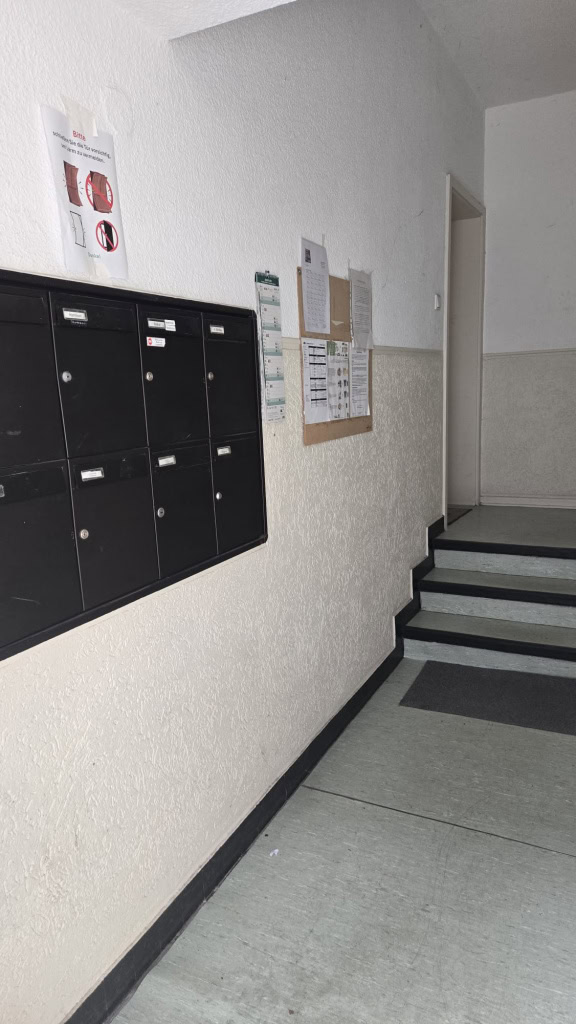 Schwarze Briefkästen in einem Mehrparteienhaus für Post- und Paketzustellung.