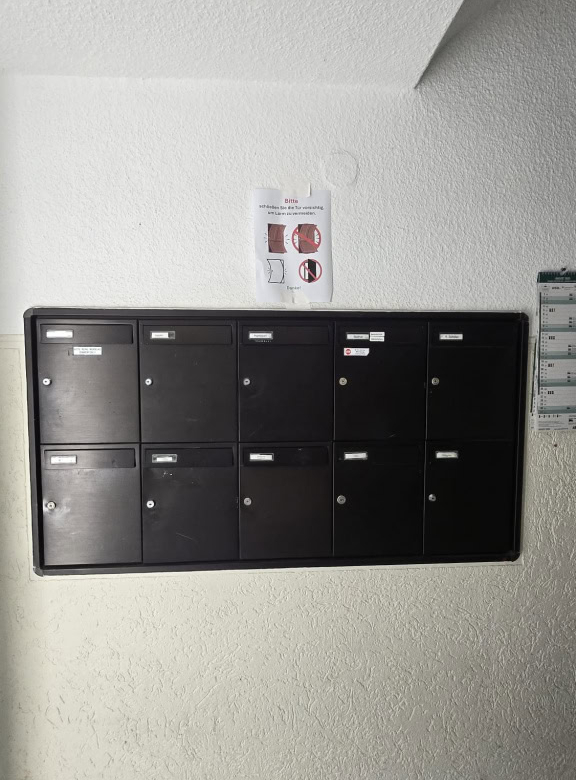 Schwarze Hauspostfächer in einem Flur bei DEM GROUP in Deutschland.