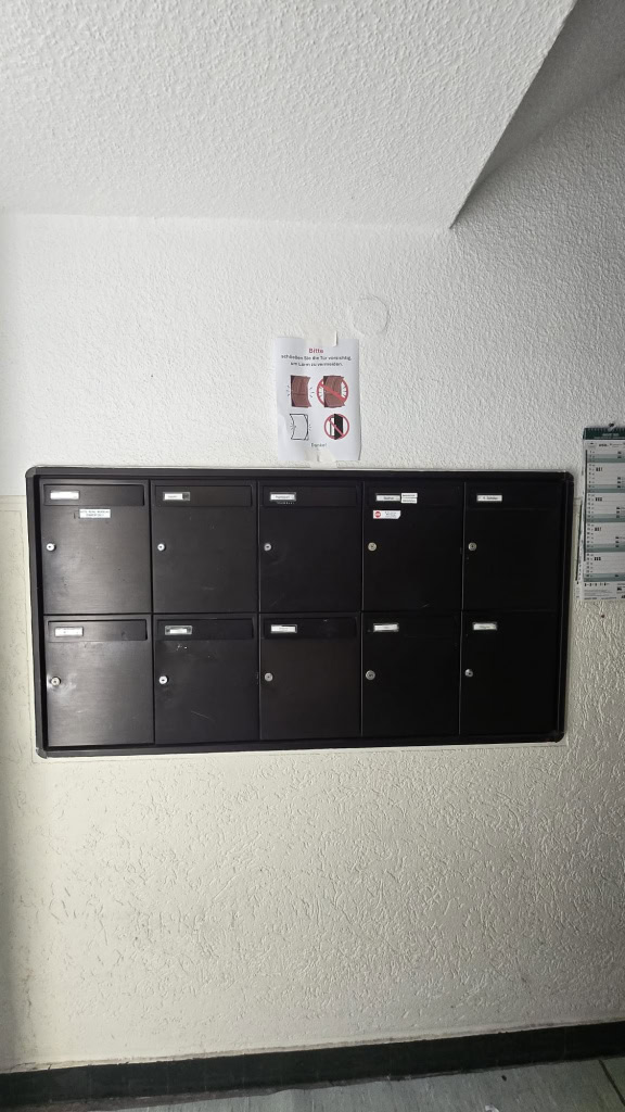 Schwarze Hauspostfächer in einem Flur bei DEM GROUP in Deutschland.