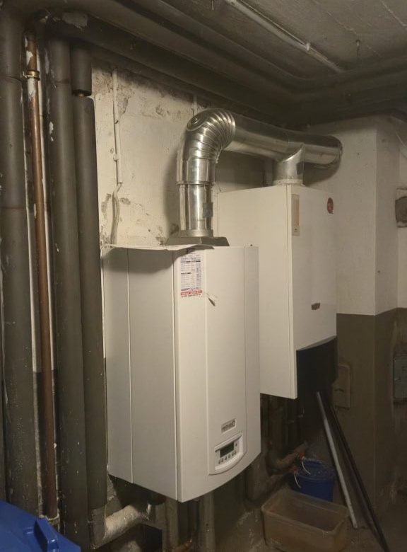 Heizkessel und Abgasleitung in einem Kellerraum für effiziente Heiztechnik und optimale Wärmeversorgung.