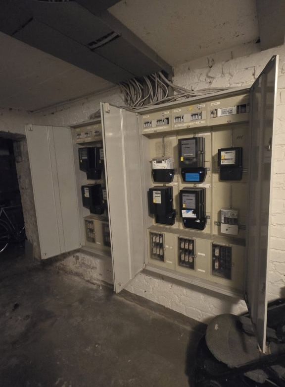 Schaltschränke mit Energiekontrollsystemen in einem Kellerraum.