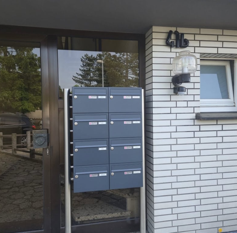 Moderne Briefkästen vor einem Firmengebäude, markantes Design.