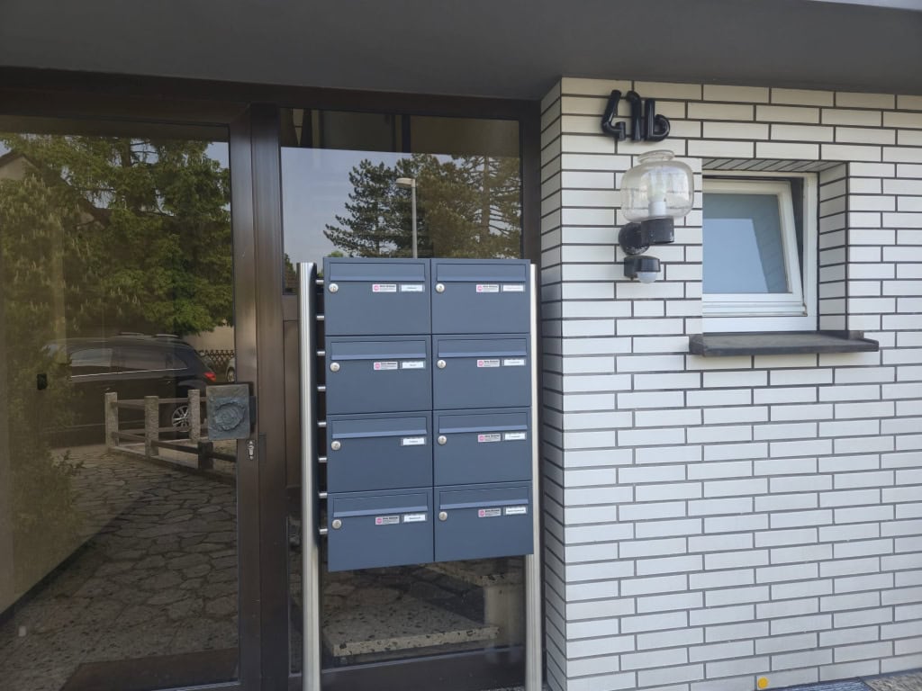 Moderne Briefkästen vor einem Firmengebäude, markantes Design.